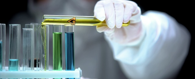 Researcher adding liquid from test tube