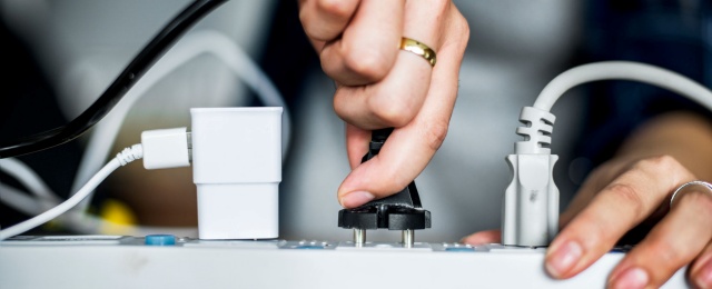 Woman plugging the wire to the outlet
