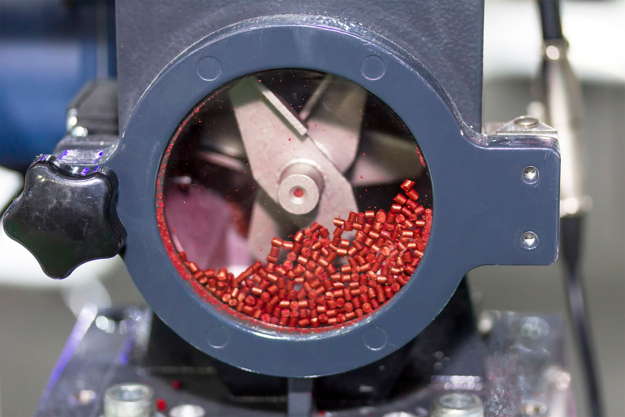 red plastic granule in crusher machine with blade of cutting prepare material for injection process